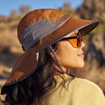 A woman in a desert setting wearing a Sunday Afternoons Adventure hat in the color Canyon.